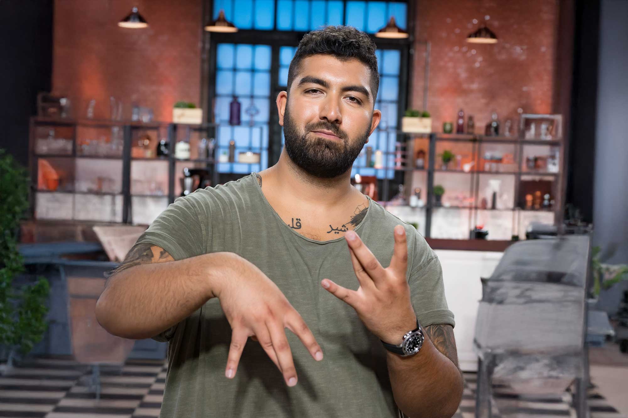 Faisal mit Gangzeichen in der Promiküche